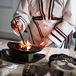 Leena allume le qulliq, la lampe à huile traditionnelle des Inuit.