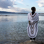 Leena wearing an amauti, looking towards the Arctic ocean.