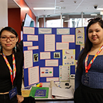 Two participants standing in front of their project board.