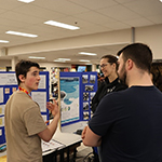 A participant presenting their project to visitors.