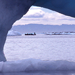 A melting ice flow with hunters in the distance.