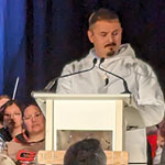 Nunavut Premier, P.J. Akeeagok speaking onstage behind a podium.