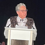 Le ministre Vandal debout derrière le podium construit sur mesure en forme de qamutik (traîneau traditionnel inuit).