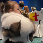 Une jeune Inuk tenant le drapeau du Nunavut.