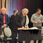 Wiiche’iwaymagon members on standing onstage during the signing ceremony.