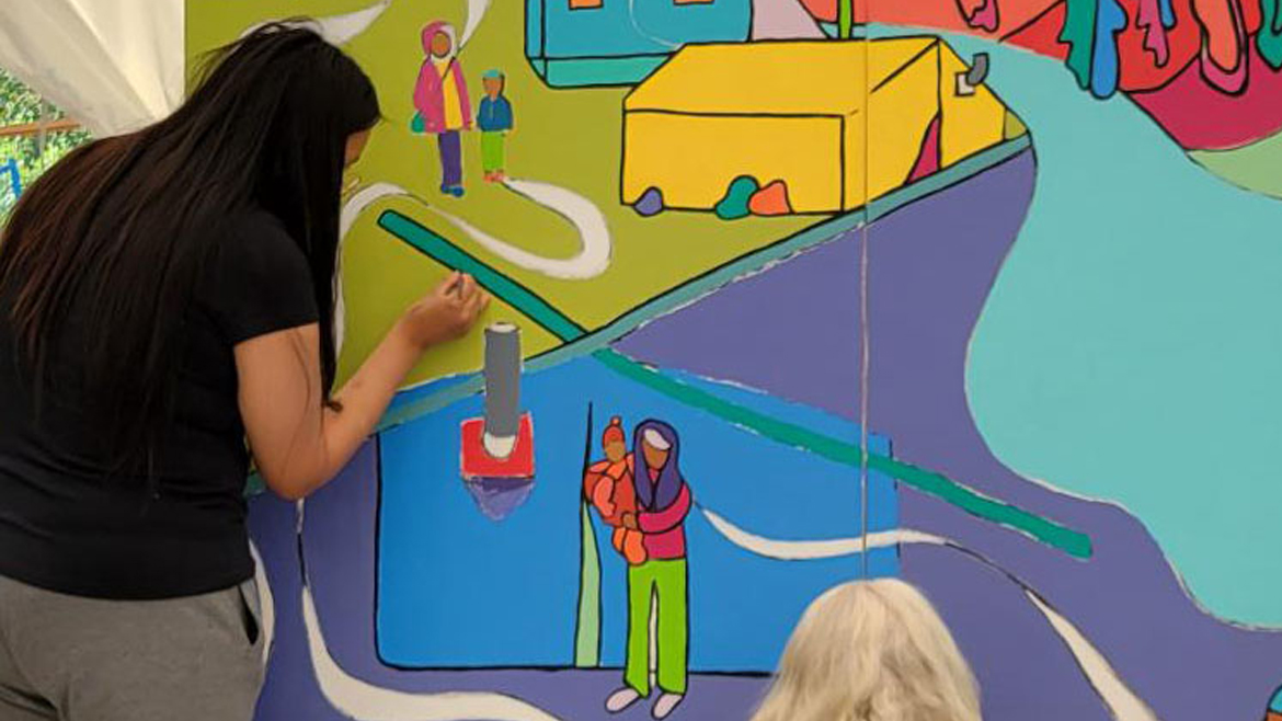 Close-up of two women painting the mural.