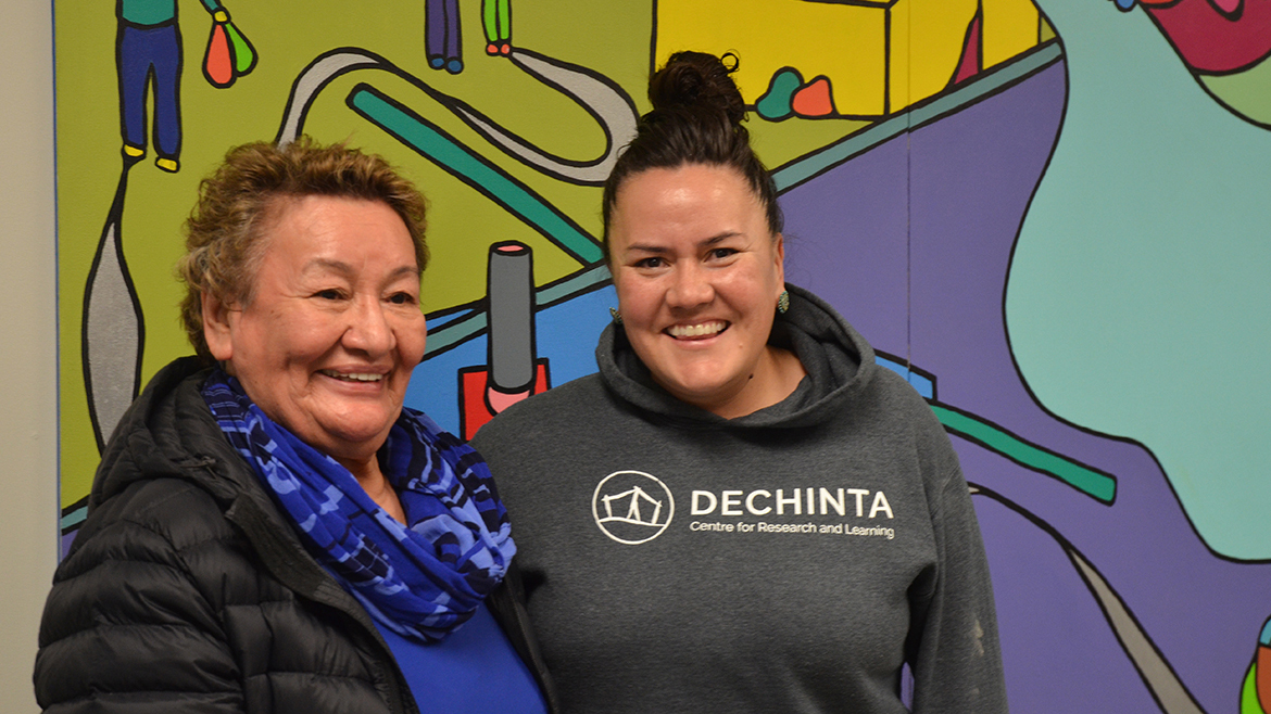 Artist Lianne Marie Leda Charlie and Elder Bernard standing in front of the mural. 