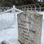 A tombstone reads: "Ici repose Rev. Sœur Marguerite Marie (Riel), décédée le 27 décembre 1883, à l’âge de 34 ans."