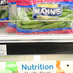 A bag of snap peas sitting on a store shelf, with a Nutrition North Canada label below it.