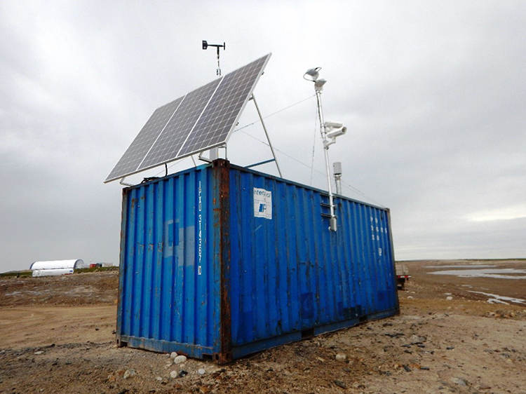 A seacan with solar panels, instruments to monitor the weather and a remote camera attached to the top of the seacan.