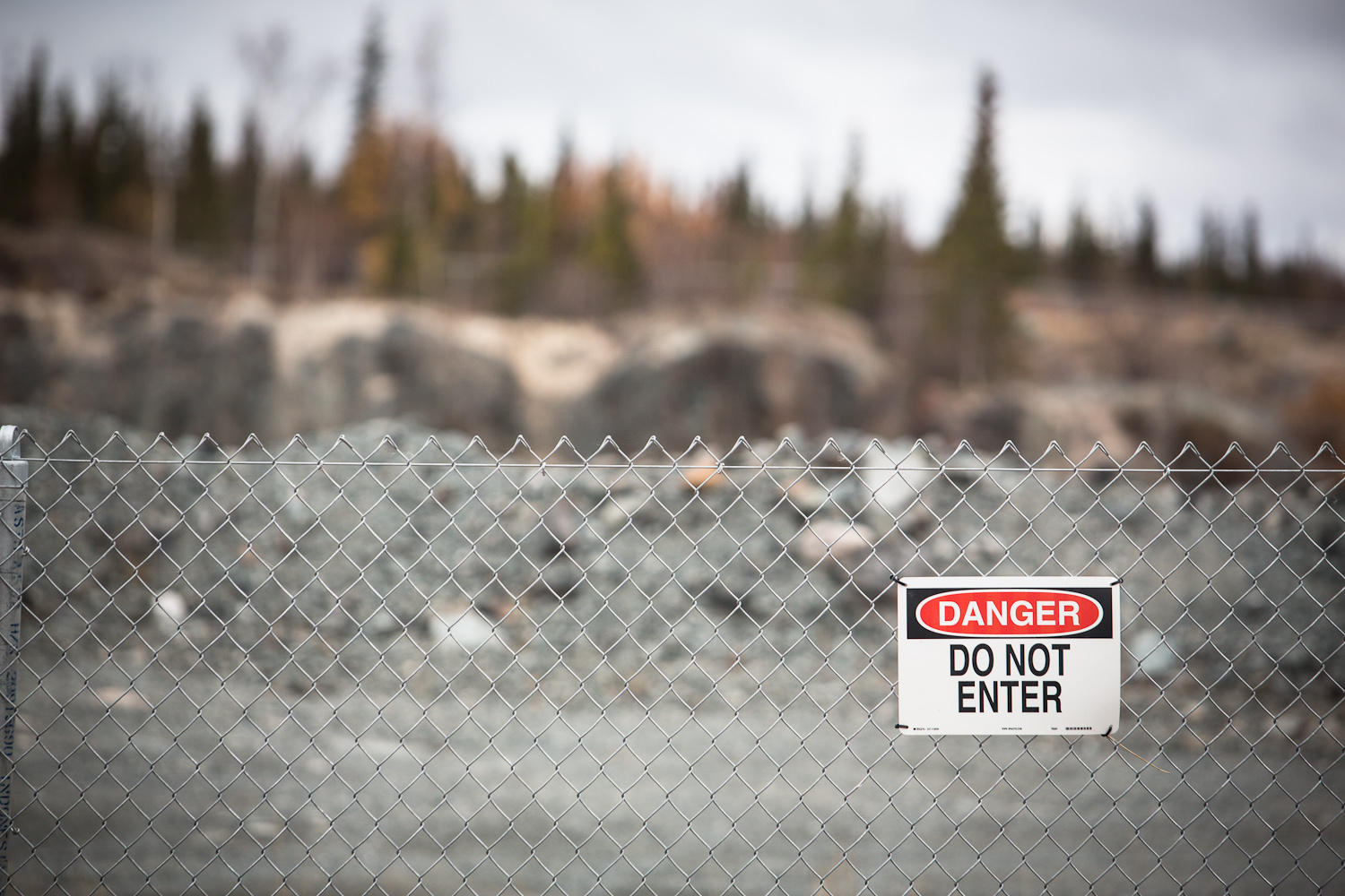 This picture shows a chain link fence with a sign on it that says 'Danger Do Not Enter'. 